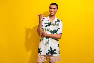 Fototapeta premium Portrait of handsome guy wear print clothes with ring in nose indicating look at empty space logo isolated on yellow color background