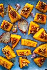 Roasted pumpkin with onion and garlic on wooden table
