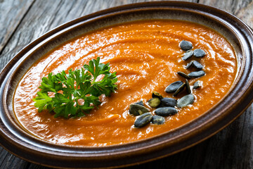 Pumpkin cream soup on wooden background
