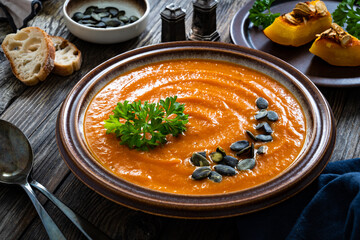 Pumpkin cream soup on wooden background
