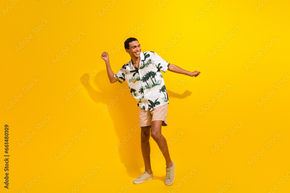 Wall mural Full size photo of handsome young guy dancing have fun party dressed stylish palms print outfit isolated on yellow color background - Wall murals