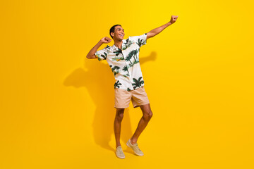 Fototapeta na wymiar Full body photo of attractive young man dancing have fun dressed stylish palms print clothes isolated on yellow color background