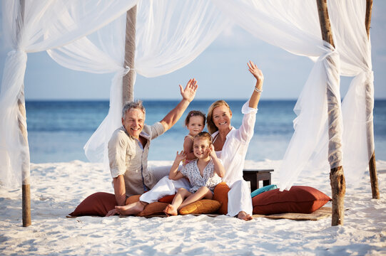 Portrait, wave and family with vacation, beach and relax with adventure, travel and tourism. Face, parents and mother with father, children and seaside holiday with gesture, tent and summer break
