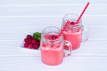 Raspberry smoothie red colorful fruit juice milkshake blend beverage healthy high protein the taste yummy In glass drink episode morning on white wood background from top view.