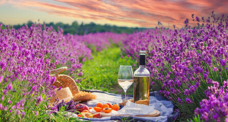 wine, fruits, berries, cheese, glasses picnic in lavender field Selective focus
