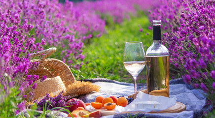 wine, fruits, berries, cheese, glasses picnic in lavender field Selective focus