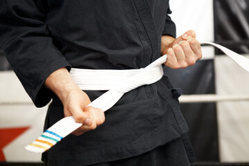 Man, hands and white belt in karate of martial arts beginner, training or discipline at dojo....