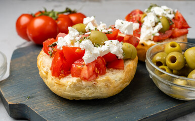Cretan appetizer of tomatoes and cheese on a bun, Dakos close-up.