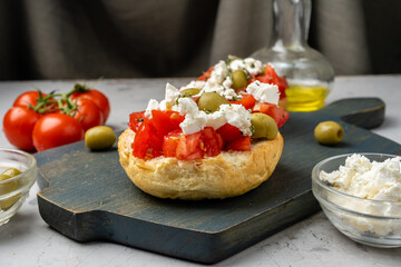 Toasted bun with ripe tomatoes, feta cheese and olive oil, Dacos.