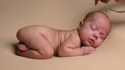 Sleeping newborn cute baby girl during first week of life. 4k slow motion120 fps raw video. Happy family concept. Small baby sleep in bed with small bear toy in hand and nipple