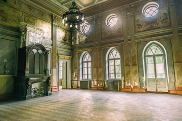 Fototapeta na wymiar empty hall in Sharovsky Castle with chandelier, fireplace and arches on windows, Kharkiv region