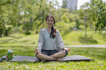 Young Asian woman revitalized through park yoga, meditation, aligning body, mind, restoring energy.