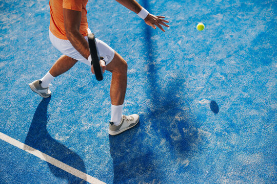 Intense padel match: Young athlete dominates championship game with a forehand strike