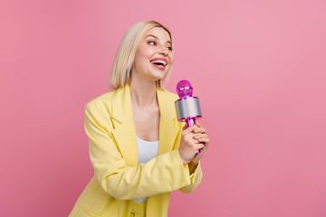 Photo of cheerful lovely person hands hold microphone enjoy sing empty space isolated on pink color background