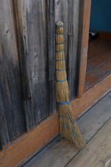 Straw Broom and Fall Leaves on Wooden Stairs