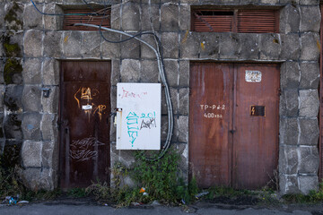 The metal doors of the entrance to the transformer in the wall of red brick
