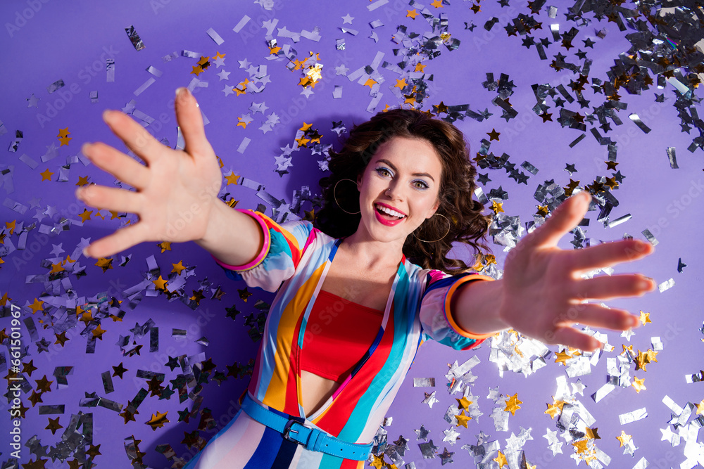 Wall mural High angle photo of adorable funny girl dressed striped overall lying floor rising arms enjoying disco isolated violet color background