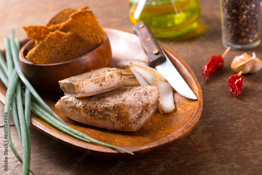 Wall mural pork fatback with spices, rye bread and green onion on wooden table