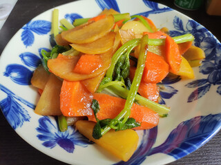 potato slice scrambled with carrots and green vegetables in the blue plate