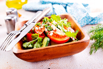 tomato, cucumber and onion salad in wooden bowl. fresh salad