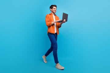 Full body profile photo of attractive cheerful young person hold use netbook walking isolated on...