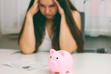 Sad woman holding her head over utility bills. The concept of rising prices for heating, gas,...