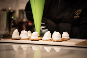 Preparation of a french meringue . Green pastry bag with a filling.