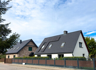 Elegant single family houses in Poland seen from the street, fence and roof as main features.