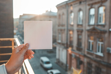 Postcard template in hands on the background of an ancient city