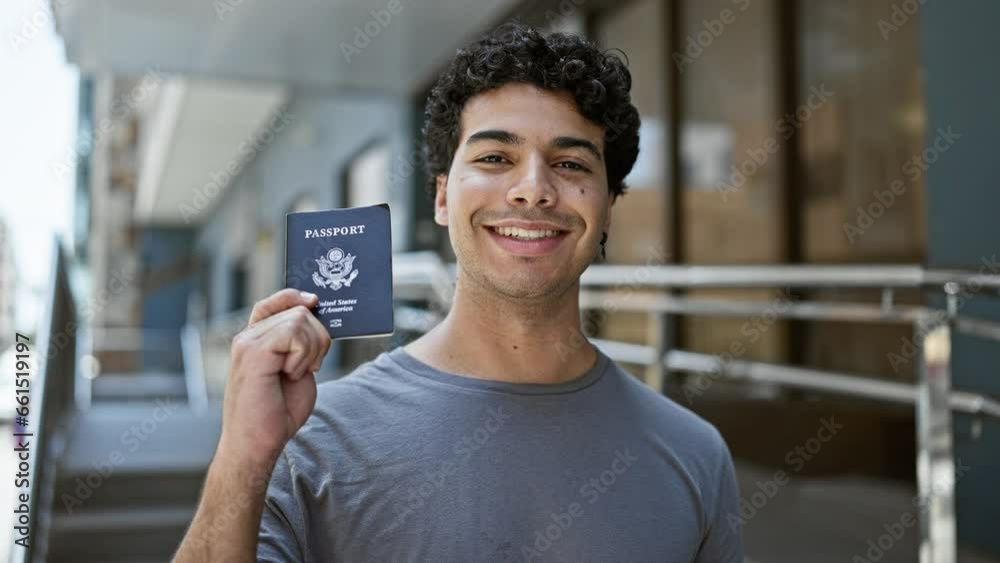 Poster Young latin man smiling confident holding united states passport at street