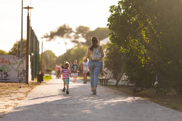 Obraz premium Cute blond boy climbing walking in the park with his mother in a holiday
