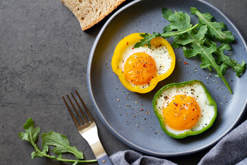 Yellow and green pepper with fried eggs and arugula, concept of healthy and delicious breakfast