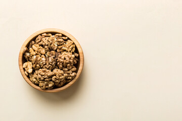 Fresh healthy walnuts in bowl on colored table background. Top view Healthy eating bertholletia concept. Super foods
