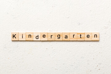 kindergarten word written on wood block. kindergarten text on table, concept