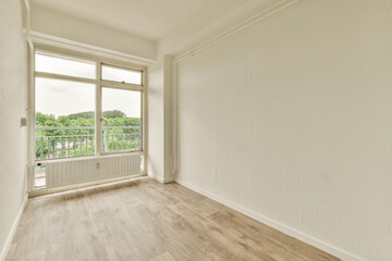 an empty room with wood flooring and white paint on the walls there is a large window in the corner