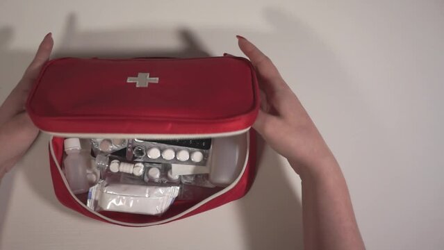 view from above. the woman opens the first aid kit. first aid kit and pills close-up. a child is sick. slow motion video. High-quality shooting in Full HD