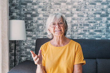 Head shot aged woman qualified psychologist looks at cam during psychological support session on-line counselling with client over telecommunication app. Chat via teleconference with relatives concept
