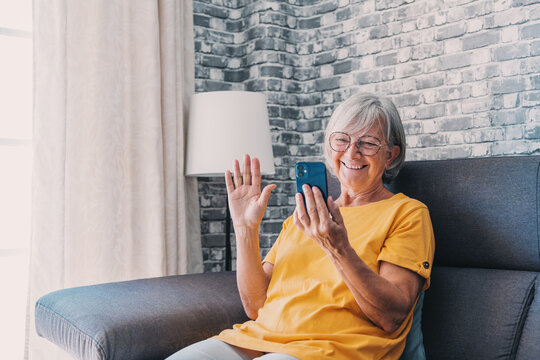 Happy Elderly Lady Talking On Cellphone, Making Call From Home, Speaking To Family On Mobile Phone With Toothy Smile. Senior 70s Woman Consulting Doctor On Cellphone, Chatting To Friend, Laughing.