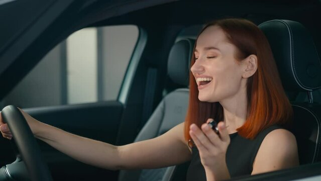 Excited female client buyer happy smiling woman inside new car owner showing keys to camera laughing enjoying buying auto girl in vehicle automobile salon store rent transport celebrate holding key
