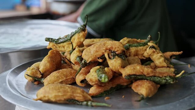 A closeup of fresh fried mirchi bajji or fried fritters on a plate at a hotel