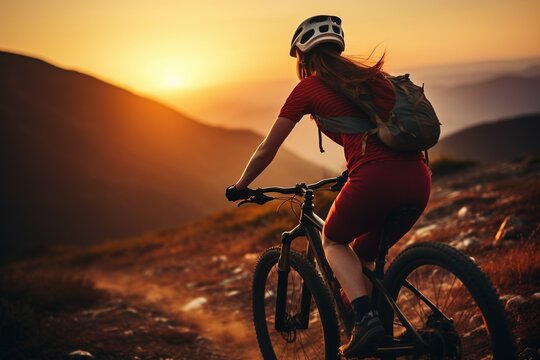 Young woman riding bicycle on mountain trail, cyclist on sports bike