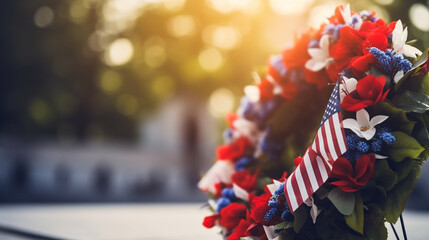 A red, white, and blue wreath placed at the base of a statue honoring fallen soldiers, with copy space, blurred background - obrazy, fototapety, plakaty