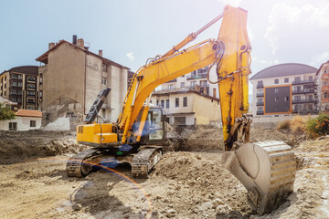 Excavator digs pit for building foundation, construction site