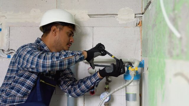 Indian plumber installs or change water filter in new apartment. Replacement aqua filter