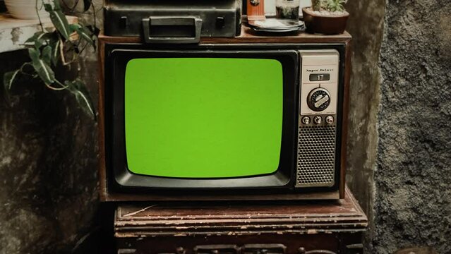 Retro TV Green Screen House Exterior Vintage Television Zoom In. Vintage television with green screen, for replacement, outside of a house. Zoom in