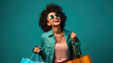Beautiful attractive smiling woman holding shopping bags posing on blue background - obrazy, fototapety, plakaty