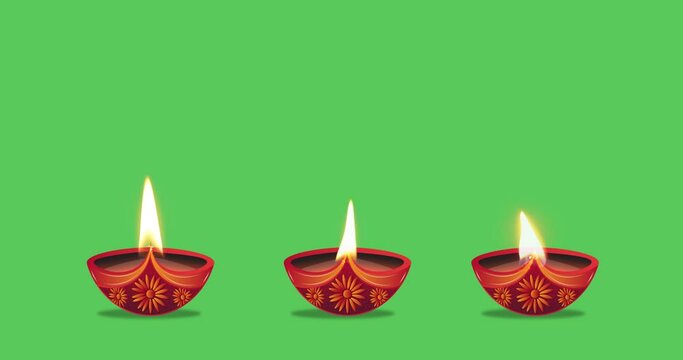 Oil lamps burning in three different ways on a green background. Diwali celebration, festival of lights, Karthika Deepa Festival.