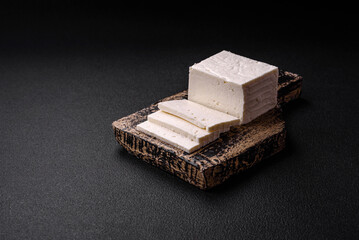 Delicious fresh ricotta cheese cut into slices with vegetables, salt and spices