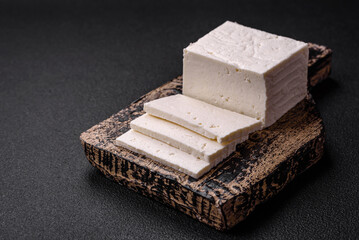 Delicious fresh ricotta cheese cut into slices with vegetables, salt and spices