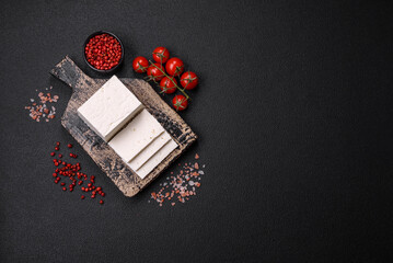 Delicious fresh ricotta cheese cut into slices with vegetables, salt and spices